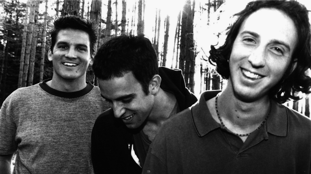 A press photo from the late 1990s for the band. Features band members Ryan Miller, Adam
Gardner, and Brian Rosenworcel in a forest.